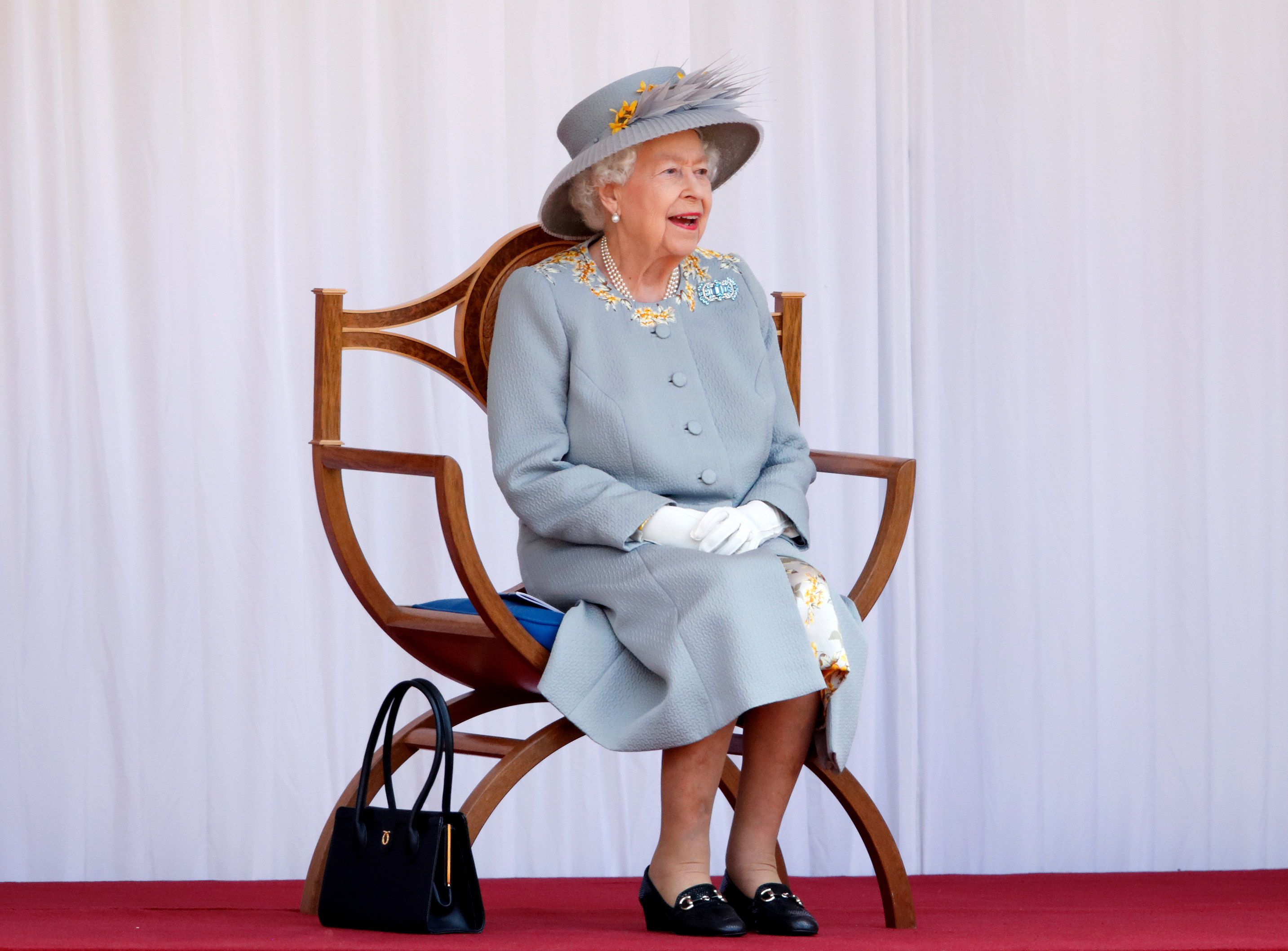 WINDSOR, UNITED KINGDOM - JUNE 12: (EMBARGOED FOR PUBLICATION IN UK NEWSPAPERS UNTIL 24 HOURS AFTER CREATE DATE AND TIME) Queen Elizabeth II watches a flypast by the RAF Red Arrows as she attends a military parade, held by the Household Division (during which The Queen&amp;apos;s Colour of F Company Scots Guards will be trooped) in the Quadrangle of Windsor Castle, to mark her Official Birthday on June 12, 2021 in Windsor, England. For the second consecutive year The Queen&amp;apos;s Birthday Parade, known as Trooping the Colour, hasn&amp;apos;t been able to go ahead in it&amp;apos;s traditional form at Buckingham Palace and Horse Guards Parade due to the ongoing COVID-19 Pandemic. (Photo by Max Mumby/Indigo - Pool/Getty Images)