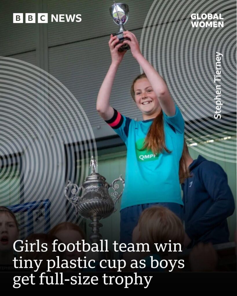 A Scottish girls football team won a tournament and was awarded a tiny plastic cup. They saw the boys team get a full-size trophy. The girls wrote to the competition’s organizers & stood up for themselves. They have now been awarded a trophy equal to the boys.