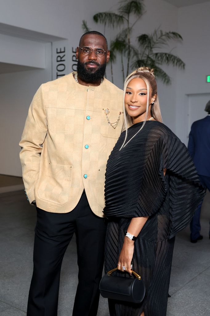 LeBron James in a high necked champagne jacket with his wife Savannah.