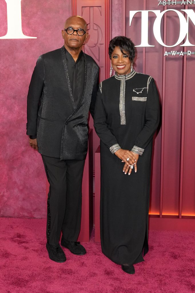 Denzel Washington in a black suit with wife LaTanya on the red carpet.