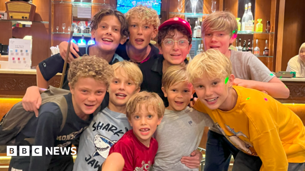 Boys have adventure of a lifetime filming BBC’s Lord of the Flies A group of young boys in a small group smile at the camera. Many of them have long blonde hair and they are wearing T-shirt and shorts.