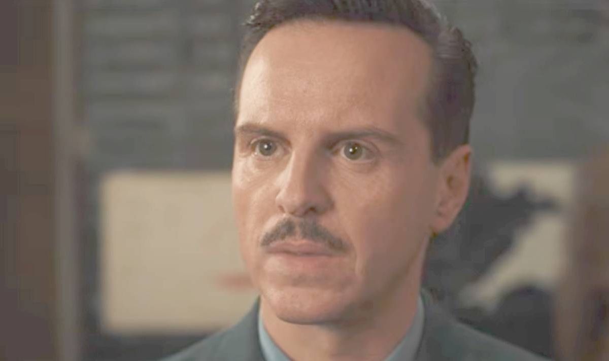 A man with a moustache looks serious