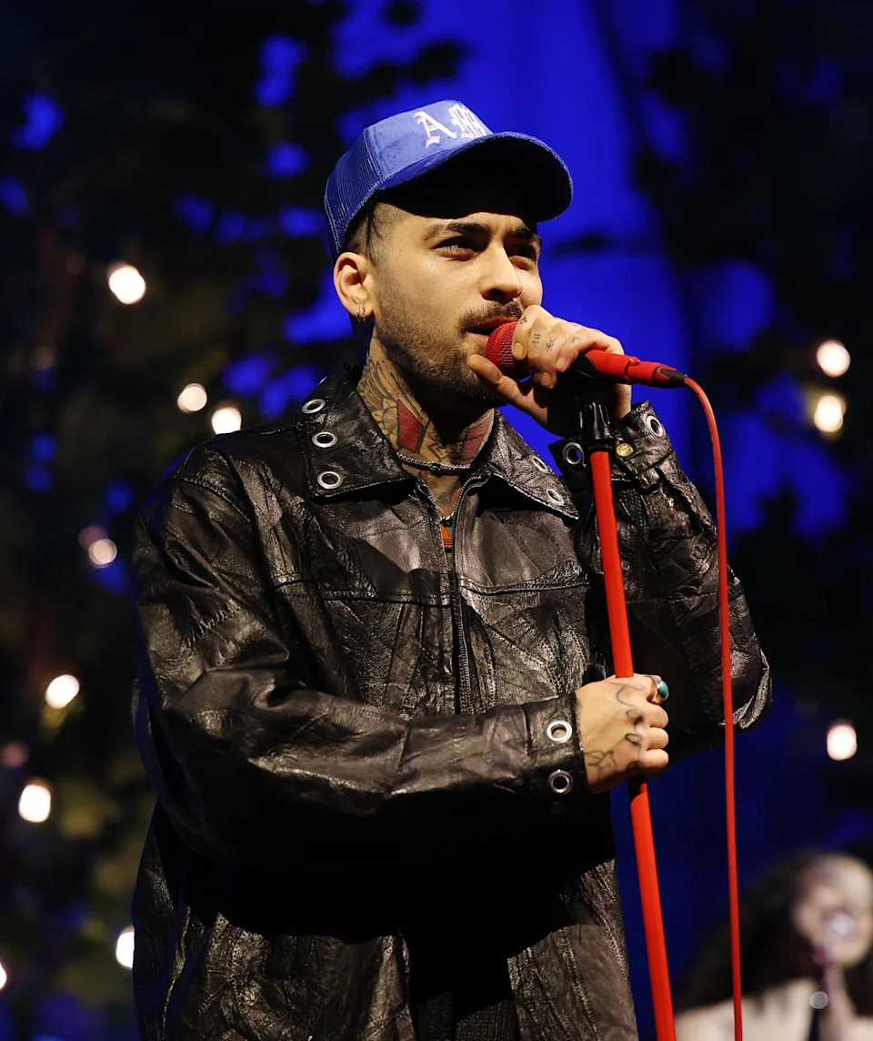 Zayn on stage, singing into a microphone