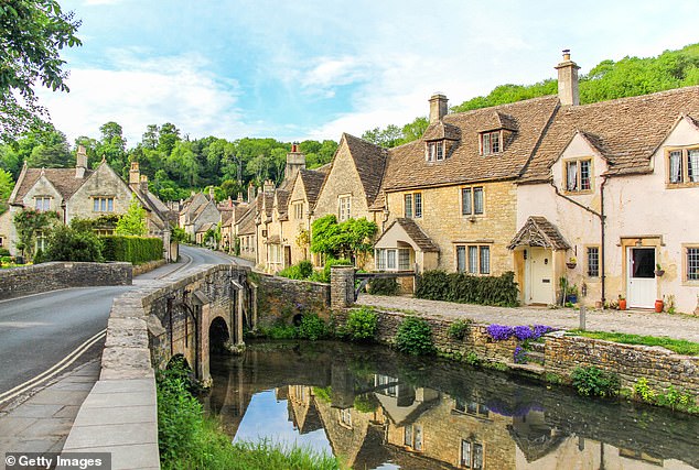 A picturesque view of cottages with Cotswold stone walls in Castle Combe, Cotswolds, England