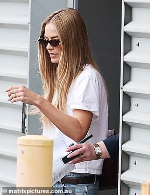 The Hollywood star was accompanied by a security guard through the terminal