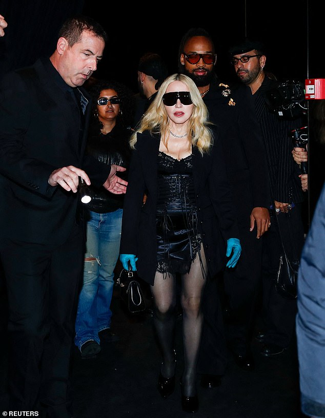 Madonna, whose boyfriend Akeem Morris, 29, followed closely behind her, accessorised her look with a diamond choker necklace, huge visor sunglasses and a mini leather handbag