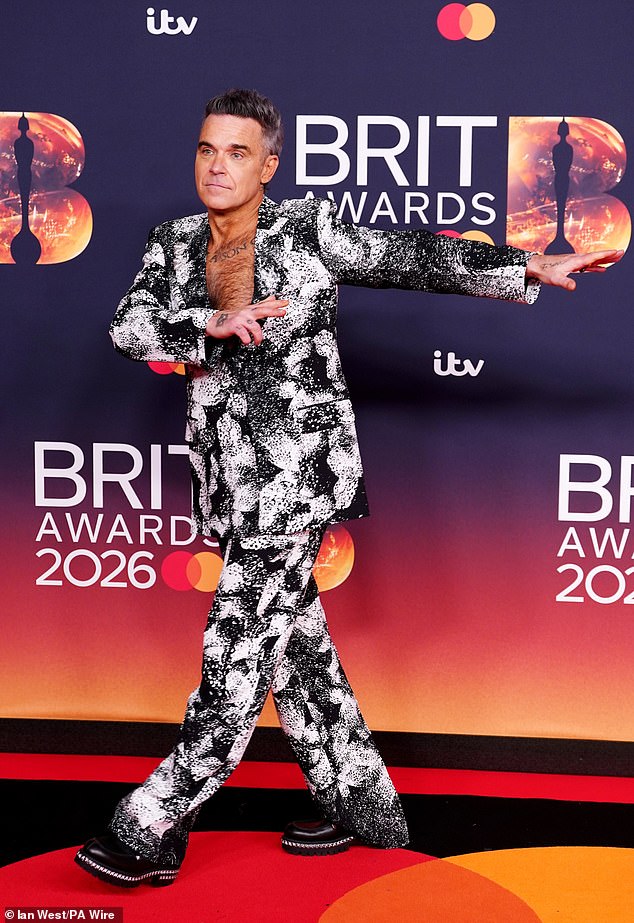 Robbie was in entertainer mode as he posed in his statement suit