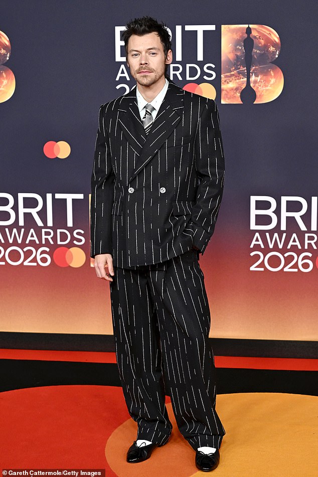Harry Styles showed off his style in a pinstripe suit from Chanel which he teamed with ballet flats and a grey tie