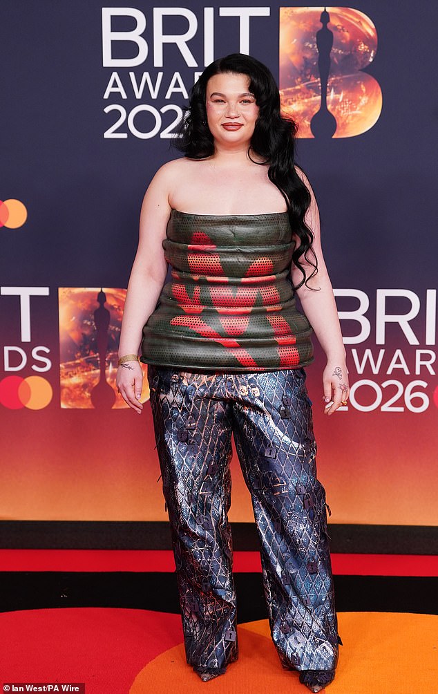 Lola Young, who is up for five awards, showed off her style as she took to the red carpet  in a strapless khaki top and blue snakeskin print trousers