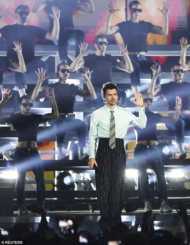 The huge group of back up dancers all wore tight black T-shirts and shades