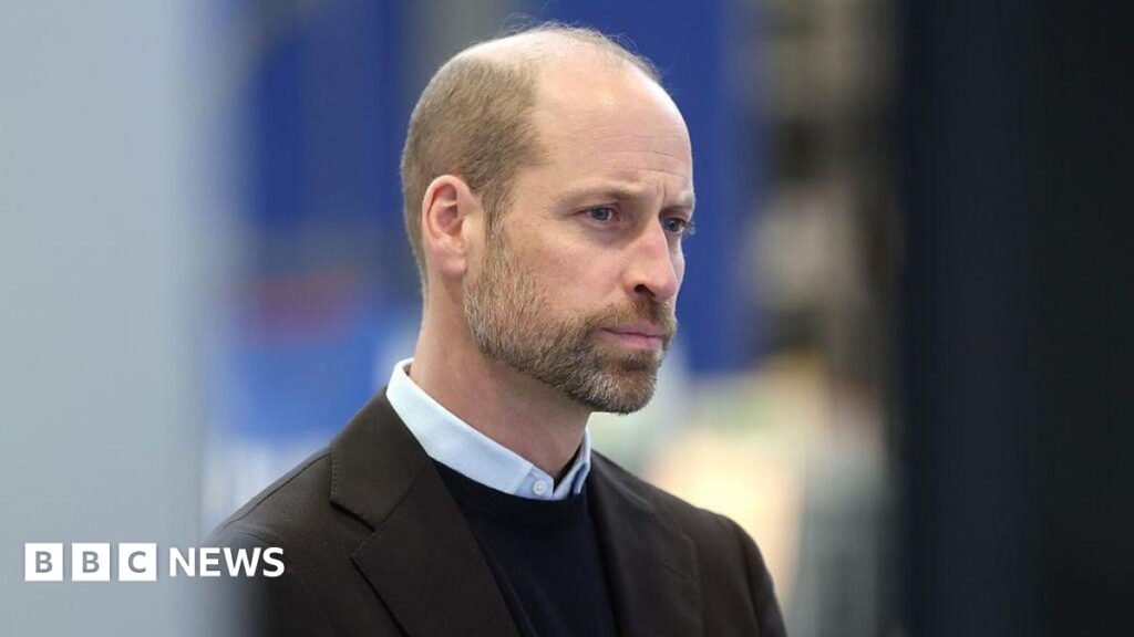 A close-up of Prince William, during a visit to the University of Bristol in January 2026. He is wearing a light shirt, with a jumper and dark-coloured jacket. He is looking to the side.