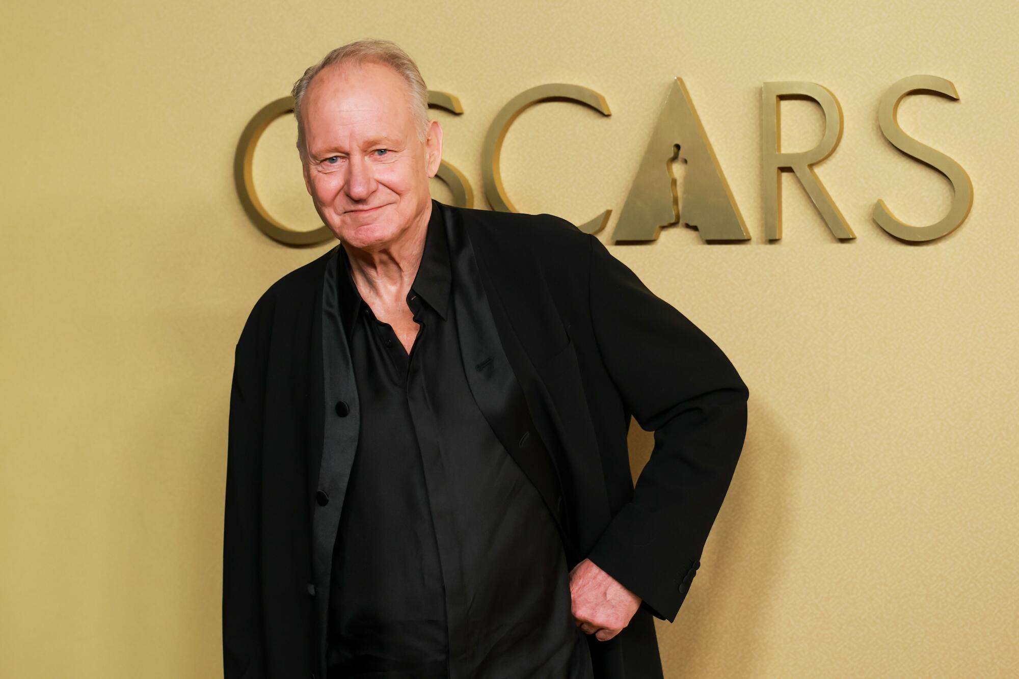 Stellan Skarsgård poses with a fist on his hip.