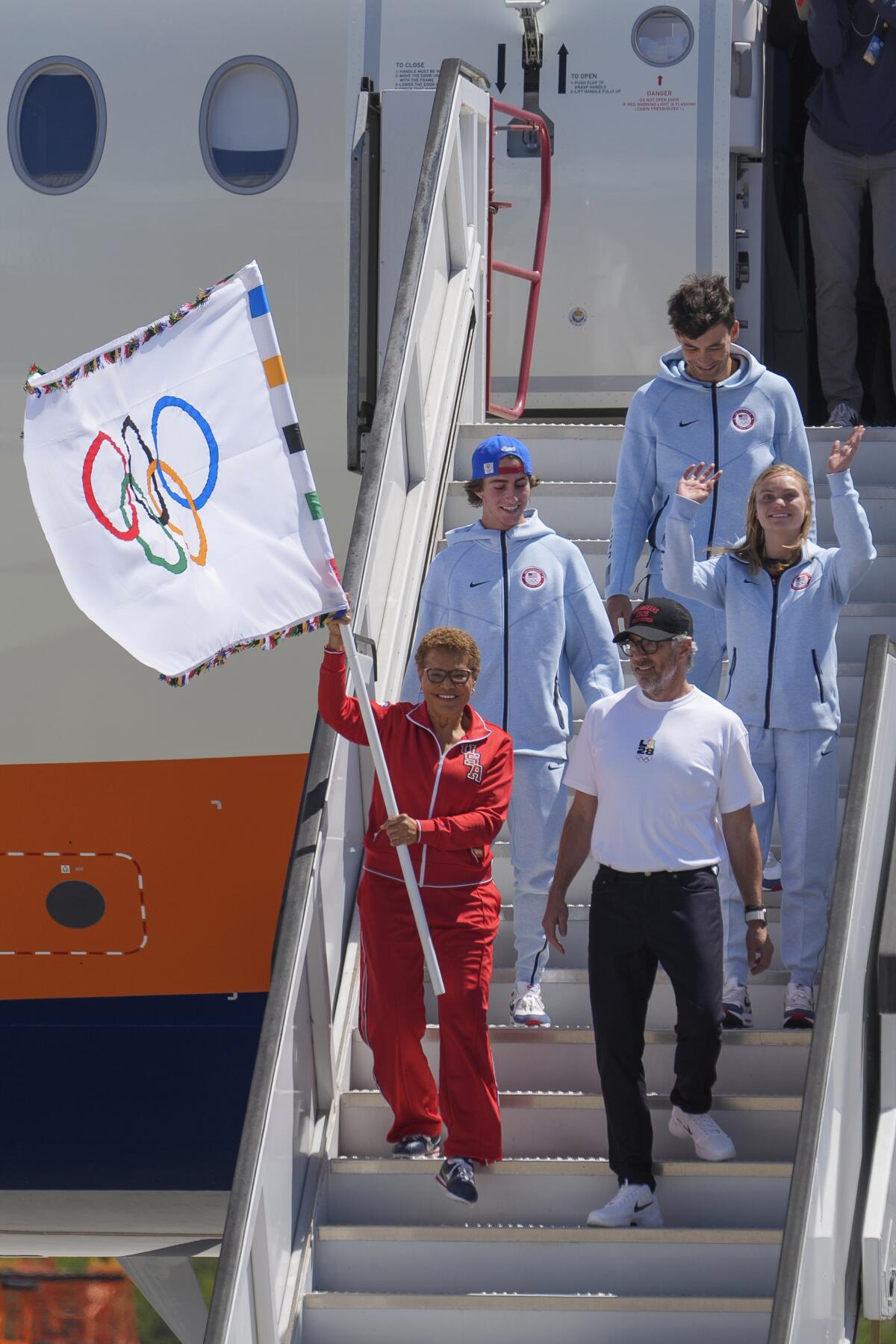 Los Angeles Mayor Karen Bass carrying the Olympic flag, LA28 chairman Casey Wasserman, 
