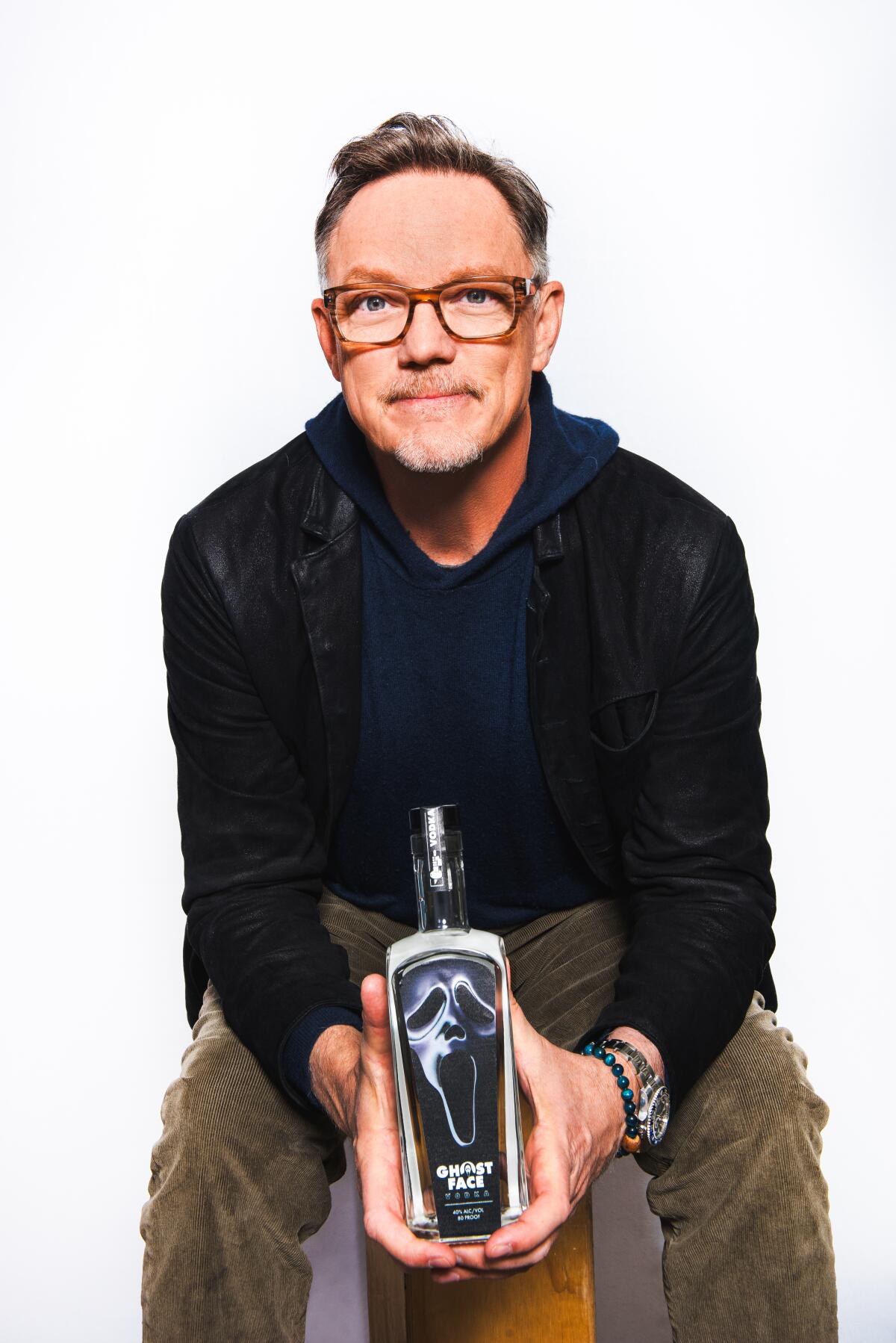 Matthew Lillard holds a bottle of Ghostface Vodka.