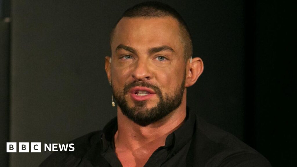 Robin Windsor pictured wearing a black shirt against a dark background