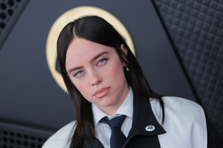 Billie Eilish wearing an "ICE OUT" pin on the GRAMMYs red carpet.