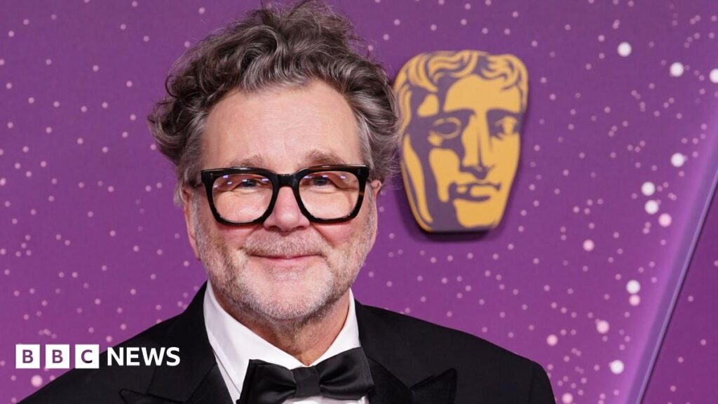 I Swear director says Baftas ‘let down’ Tourette’s campaigner John Davidson Kirk Jones in a tuxedo at the Baftas, he has glasses and grey, wavy hair