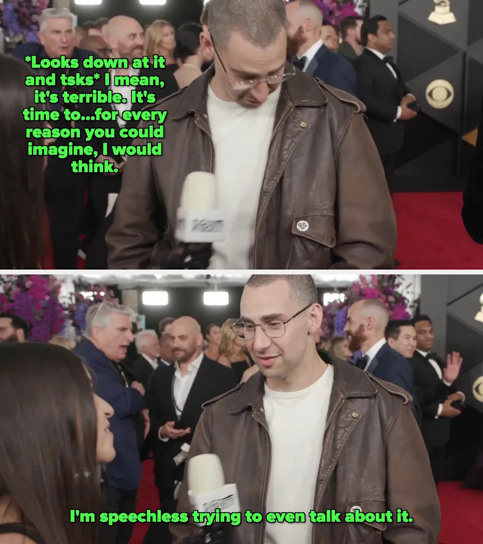 Man in brown leather jacket on red carpet with press. People and photographers in background. Black and gold decorative wall behind