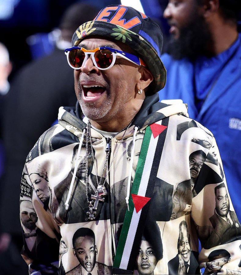 Spike Lee sporting a black history month hoodie and Palestinian bag at Knicks game