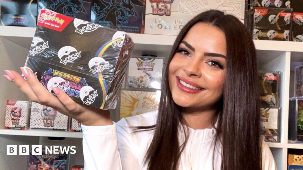 The back of a Pokémon card held close to the camera, it is different shades of blue with yellow writing. A red and white Poké ball in the centre.