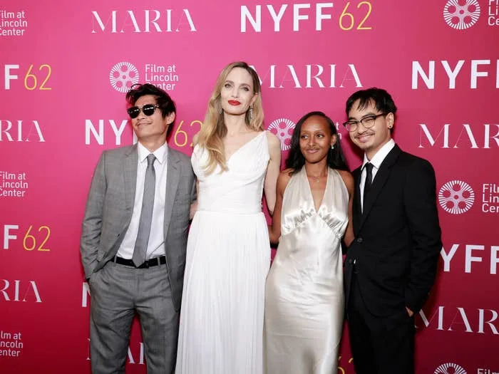 Group of four people in formal attire smiling on a red carpet at the NYFF62 event, with a backdrop featuring "Maria" and "Film at Lincoln Center."