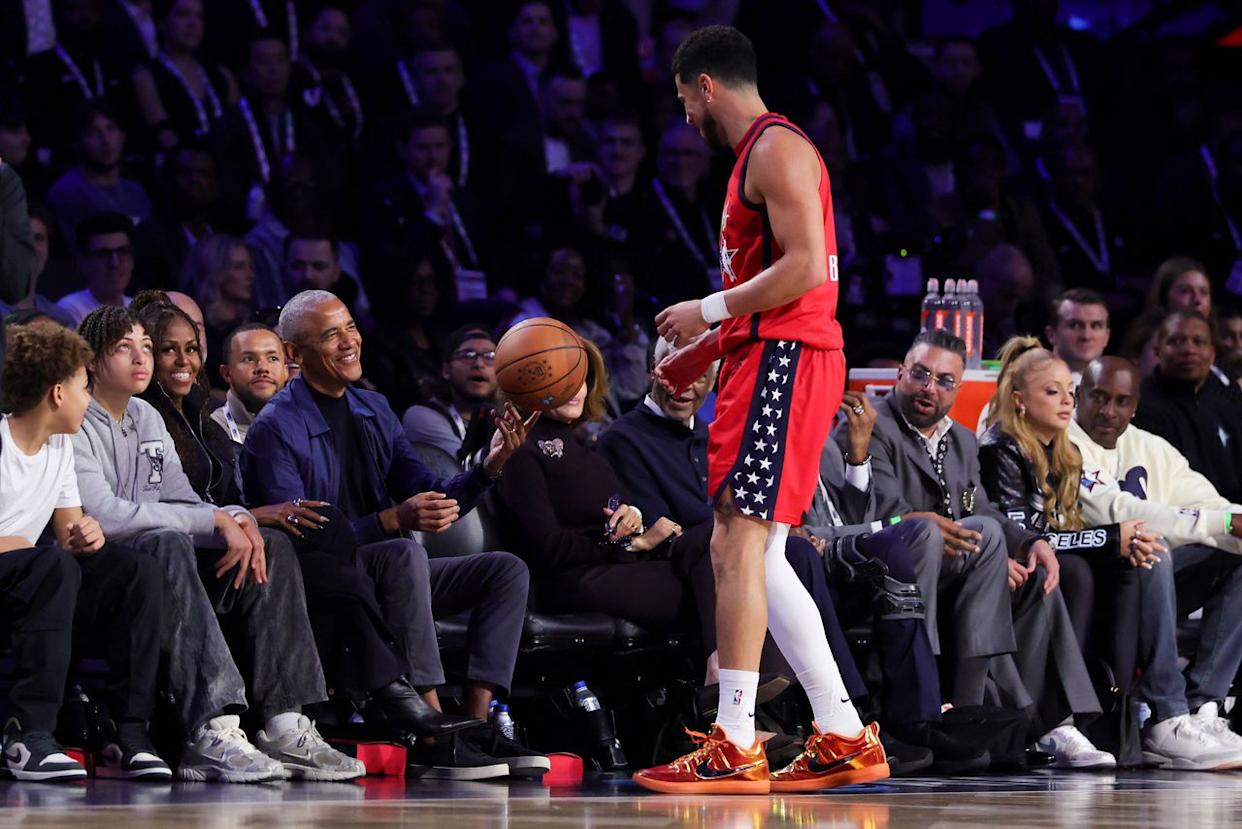 Barack Obama passes a loose ball to Devin Booker of the Phoenix Suns and Team USA Stars during the 75th NBA All-Star Game. Ronald Martinez/Getty