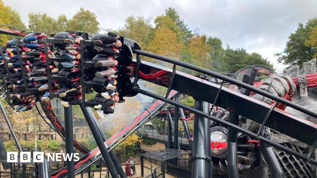 Alton Towers to remove disability pass for people with ADHD and anxiety People riding a rollercoaster, their legs dangling underneath the carriage as it speeds at an angle round the track