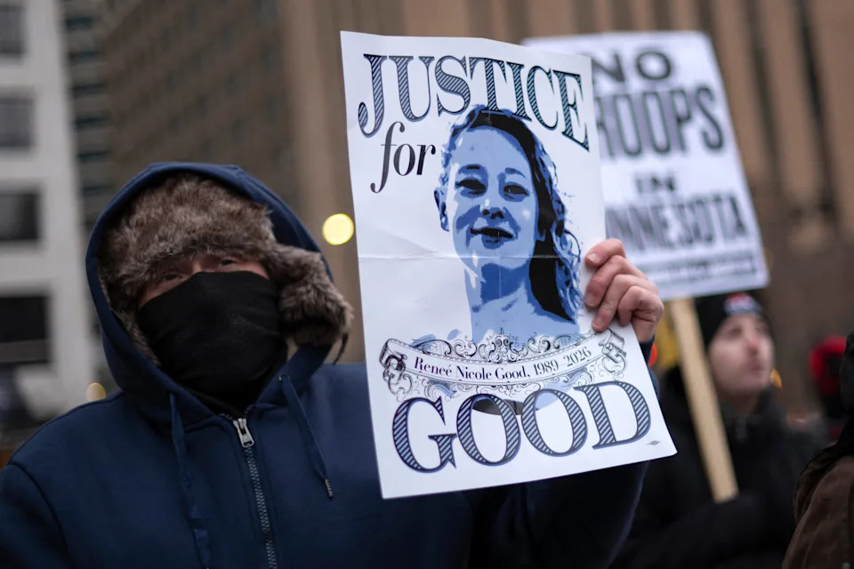 A demonstrator holds a sign with a photo of Renee Nicole Good, the 37-year-old woman fatally shot by an ICE officer, as he takes part in the nationwide 