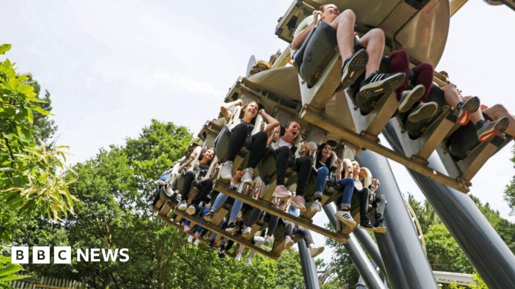 Alton Towers U-turns on plan to restrict disability pass for people with ADHD and autism A group of visitors are on a ride in Alton Towes sitting with their feet dangling from the ride. There are green trees in the background and the people are laughing and smiling. The picture is taken from the ground.