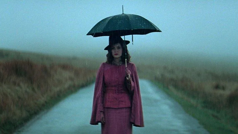 Sophie Rundle as Ada, seen holding an umbrella