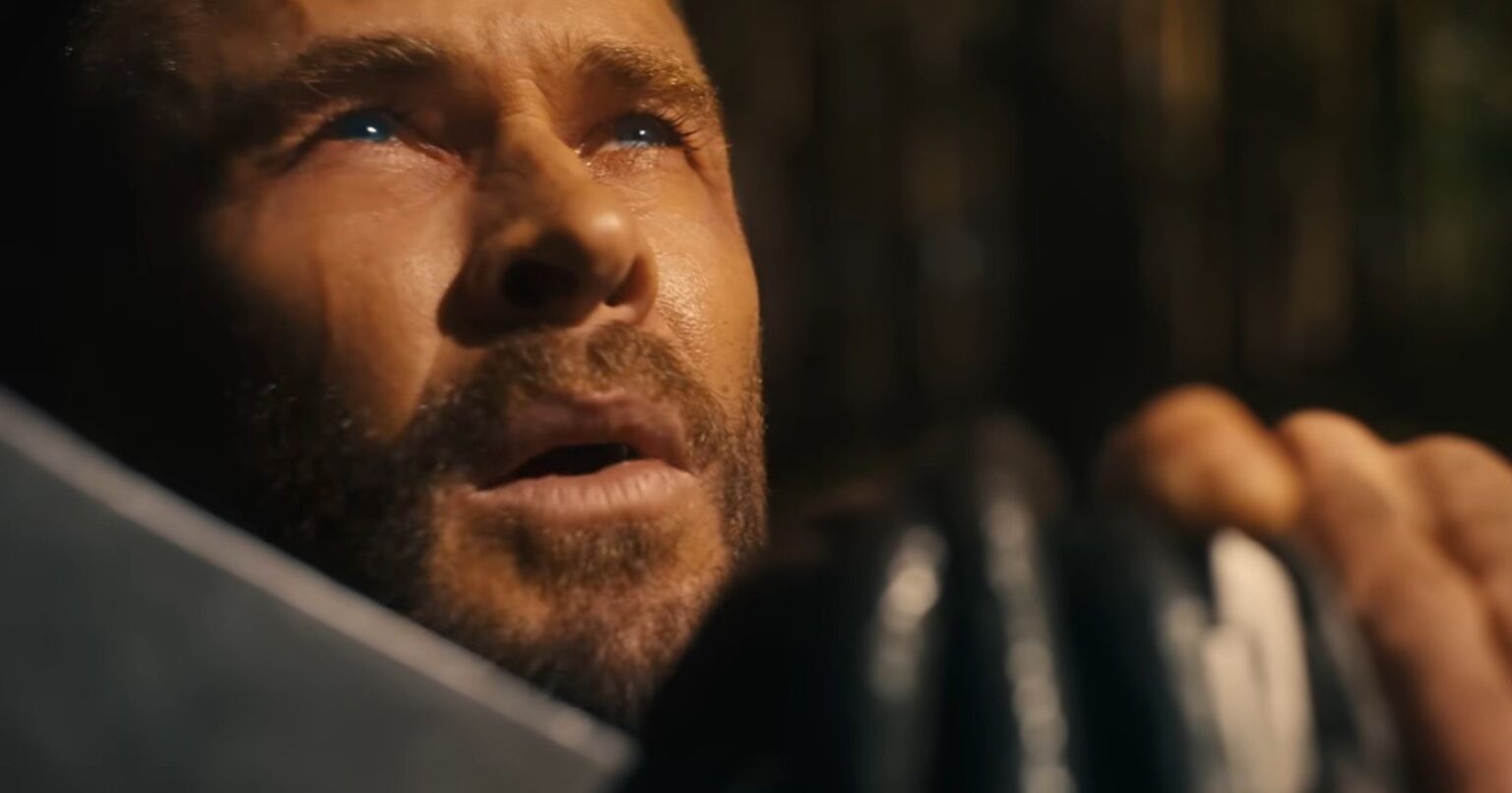 Thor with his hand resting on Stormbreaker looking up