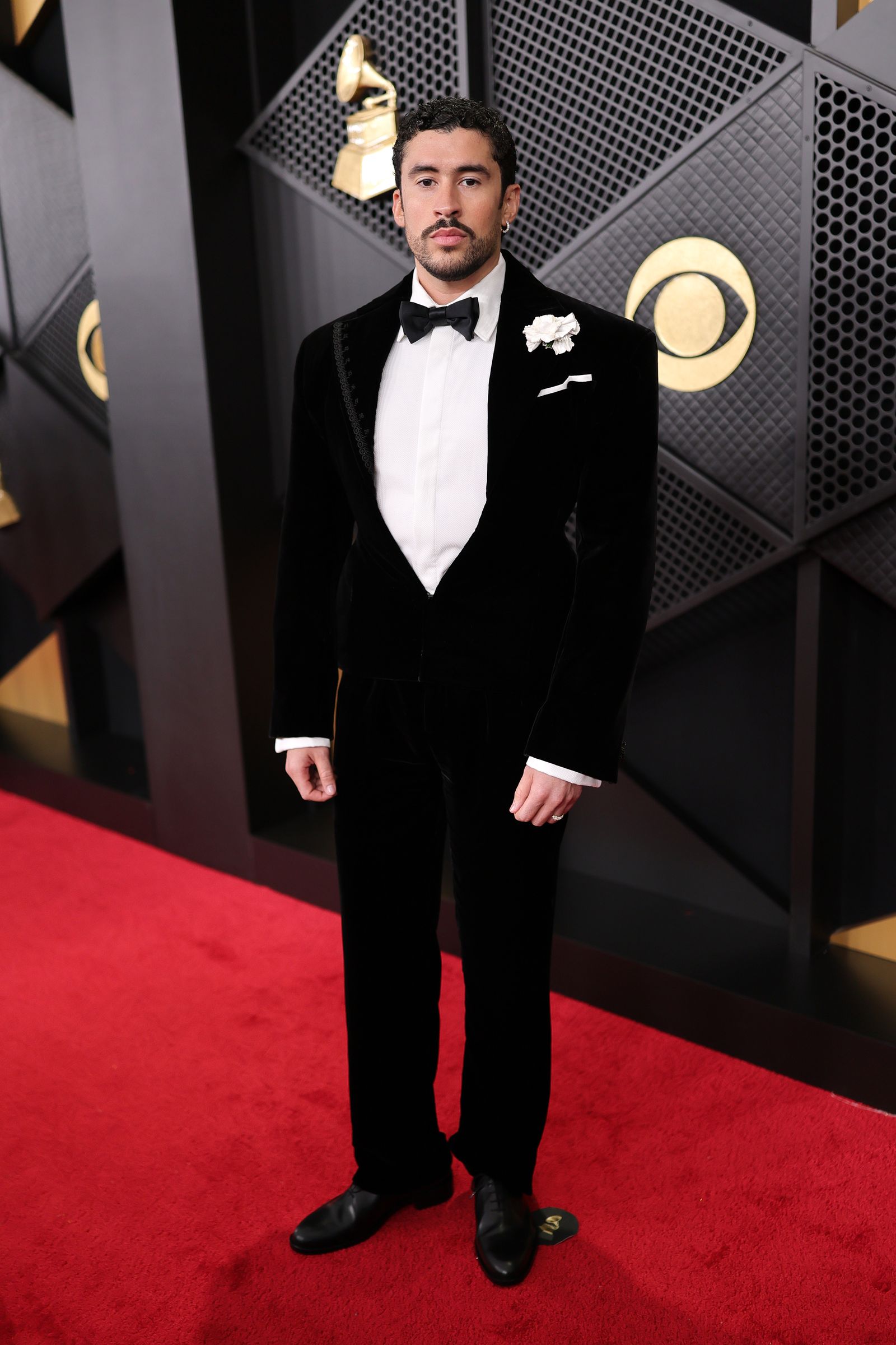 Image may contain Bad Bunny Clothing Formal Wear Suit Tuxedo Adult Person Fashion Standing and Coat