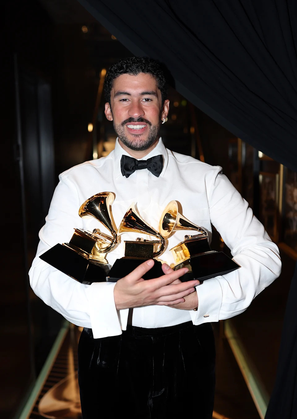 Bad Bunny poses with the Album of the Year, Best Música Urbana Album,and Best Global Music Performance Grammys. 

