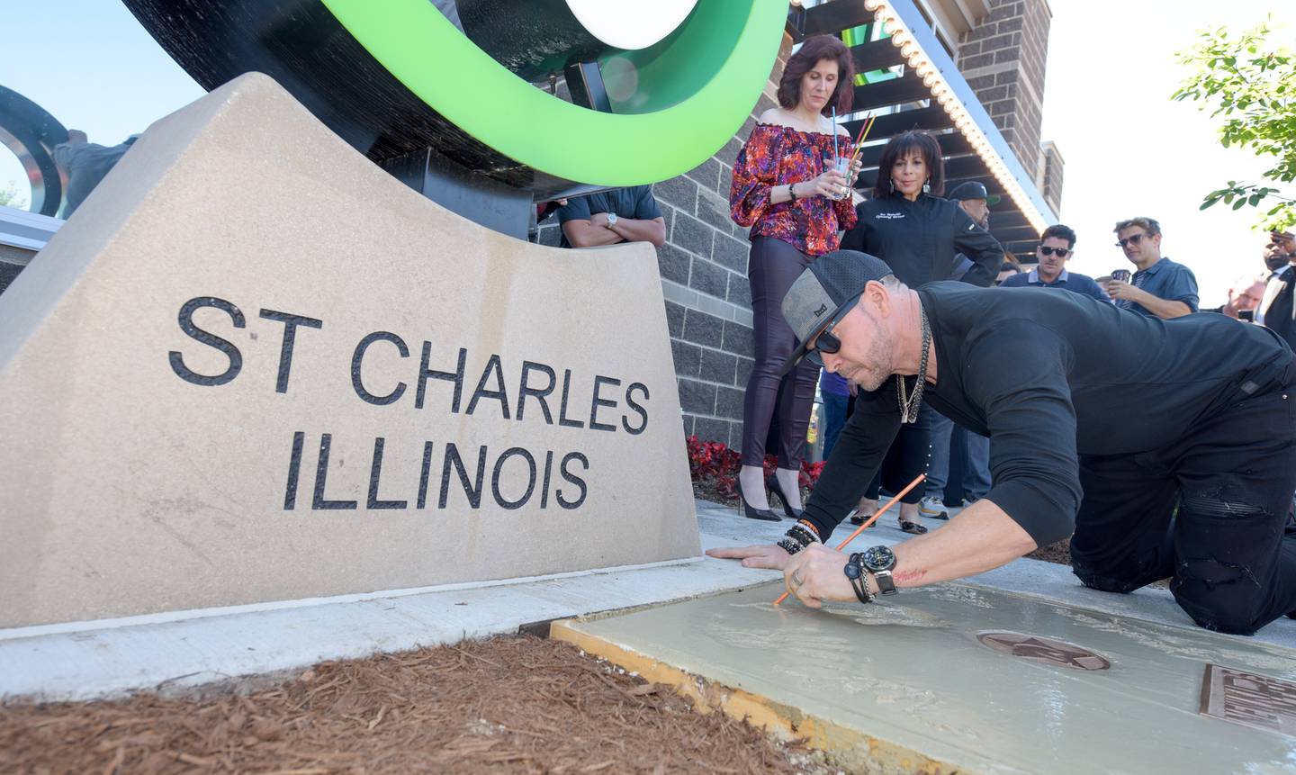 Donnie Wahlberg signs his name an places a hand print in wet cement during the Wahlk of Fame Ceremony for New Kids on the Block at the Wahlburgers in St. Charles on Saturday, June 18, 2022.
