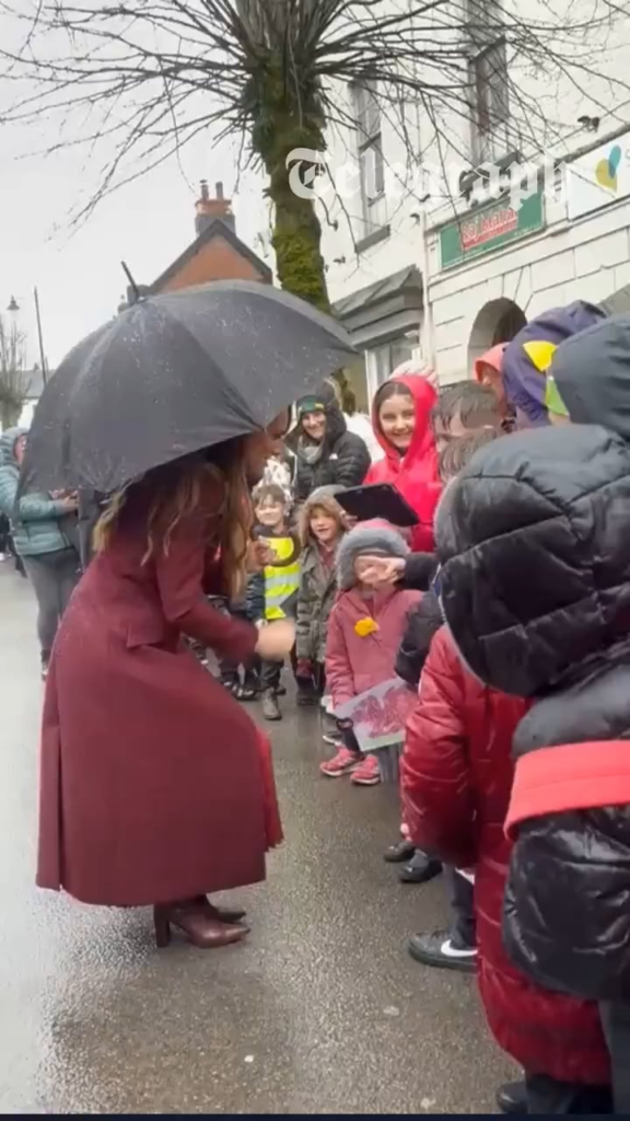 Princess of Wales playing rock paper scissors with some of the children who waited in the rain to see her