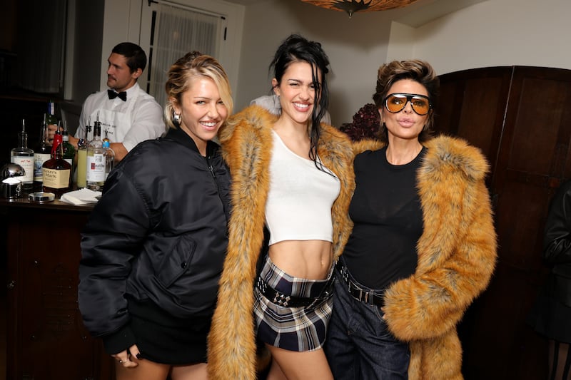Delilah Belle Hamlin, Amelia Gray and Lisa Rinna pose for the camera at an event. A bartender stands behind them.