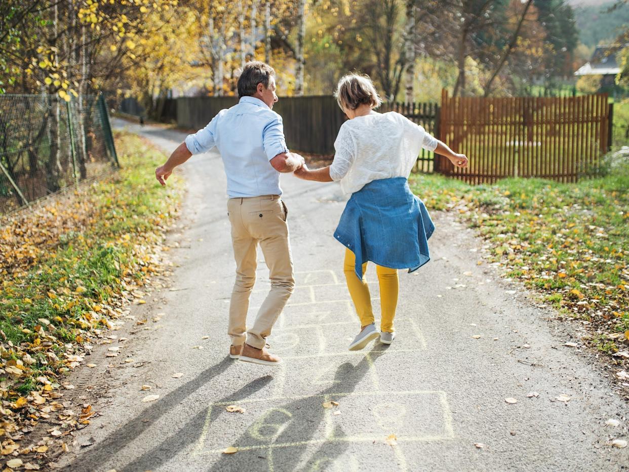 An old man and a woman are spending time outdoors, having fun.