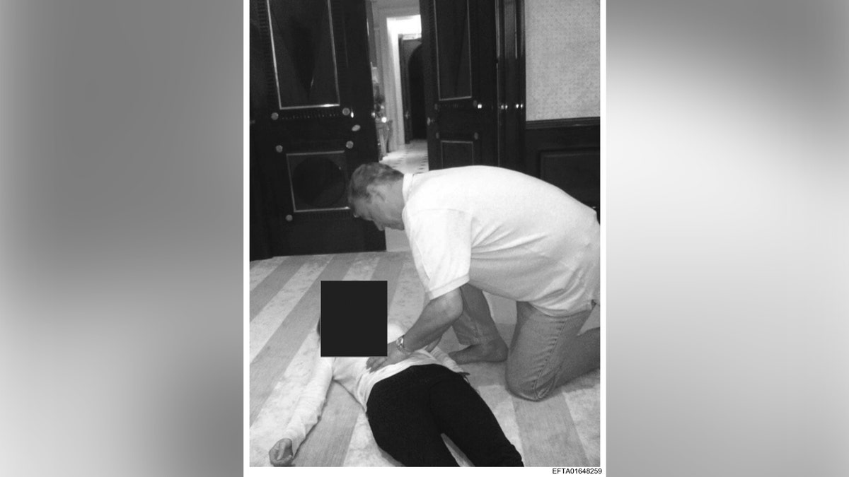 Andrew Mountbatten-Windsor knelt over an unidentified woman while resting his hand on her stomach.