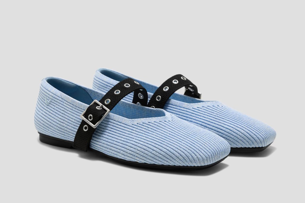 Pair of light blue Mary Jane flats with black buckled straps.