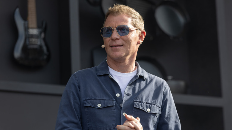 Bobby Flay wears a headset microphone while giving a culinary demonstration