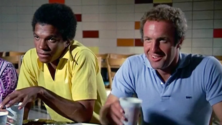 Gale Sayers (Billy Dee Williams) and Brian Piccolo (James Caan) sit together at a cafeteria table in Brian's Song