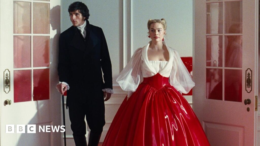 Jacob Elordi in a black suit as Heathcliff and Margot Robbie as Cathy in a white and red PVC dress