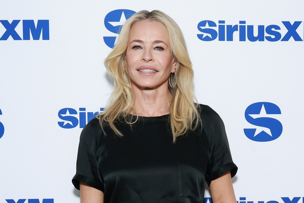 Chelsea Handler smiling in front of a white background with blue SiriusXM logos.
