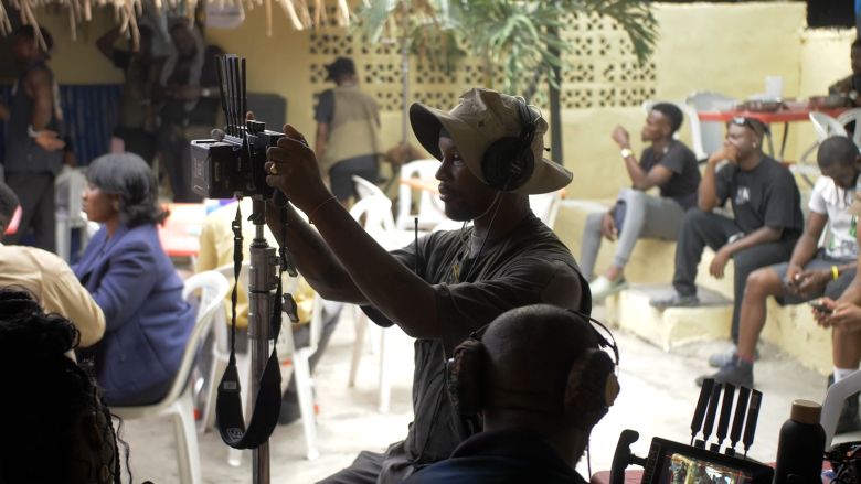 Director and writer Akinola Davies Jr. looks through a monitor on the set.