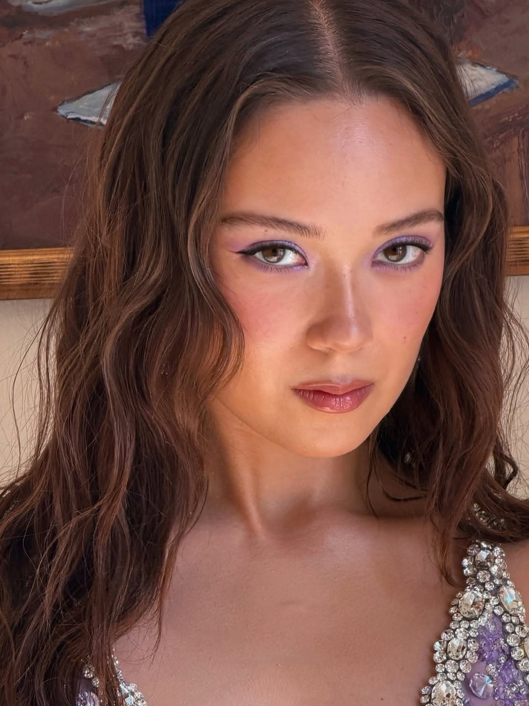 closeup of a person with long hair wearing a decorated garment