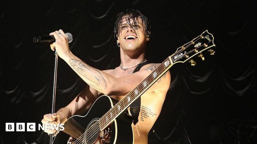 BludFest: Yungblud festival move gets mixed reviews from fans Yungblud is topless on stage. He's wearing black leather trousers and is holding a microphone looking out into the crowd. Behind him is a giant festival type stage with two screens flanking the sides with him on it.