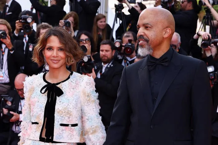 Halle Berry in a textured jacket with a bow and matching bottoms and Van Hunt in a classic suit