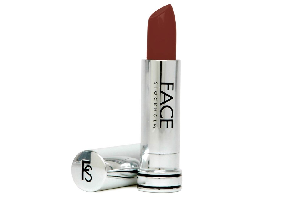 A single stick of red lipstick by FACE Stockholm with the cap removed, lying next to it.