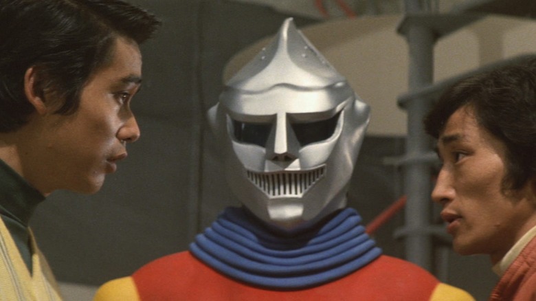 Two men speaking in front of Jet Jaguar in Godzilla vs. Megalon