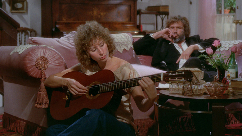 Esther playing guitar and John listening in A Star is Born